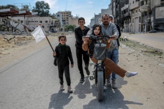 Una famiglia sfollata sventola una bandiera bianca mentre lascia Gaza City foto Afp