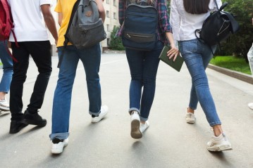 Unrecognizable teenage students in high school campus Unrecognizable teenage students in high school campus walking at break, crop