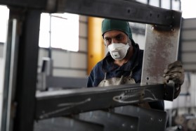 Un lavoratore con la mascherina in una fabbrica a Milano